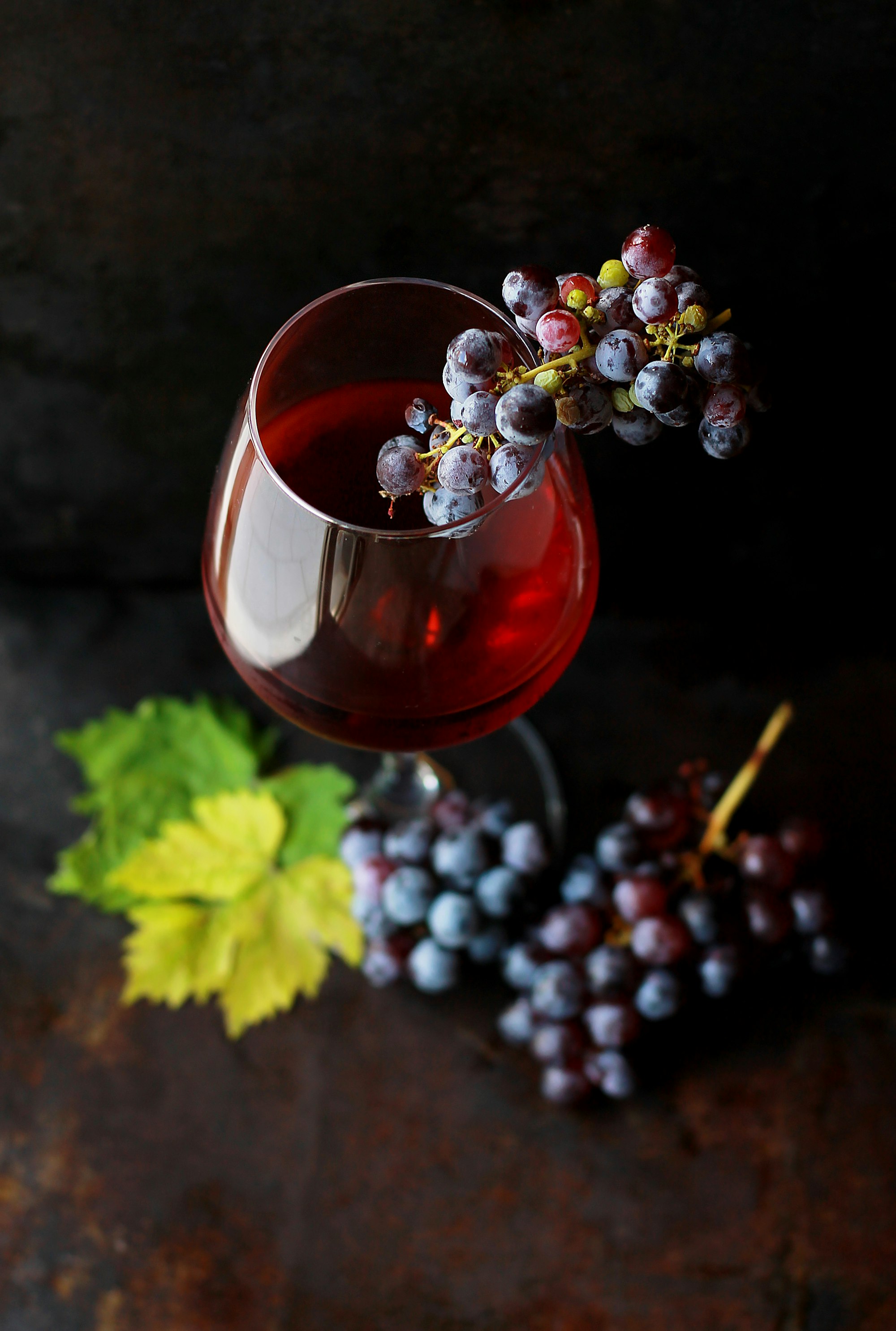 A glass of Trezee red beside fresh grapes